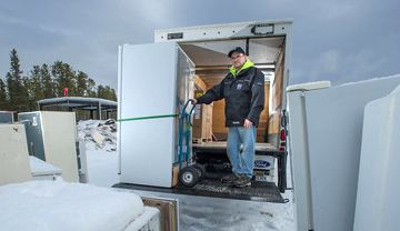 Delivery man picking up old inefficient fridge