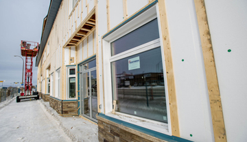 Foam insulation being installed on outside of building.