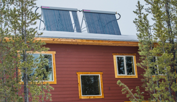 Solar hot-water tubes o the roof of a red house