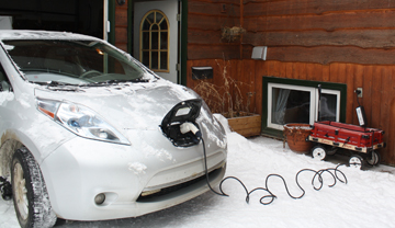 Used electric car plugged into house outlet