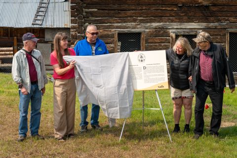 De gauche à droite : Tim Green, Commission du patrimoine historique du Yukon; Sierra van der Meer, gouvernement du Yukon; Carl Sidney, Commission du patrimoine historique du Yukon; Zena McLean, Commission du patrimoine historique du Yukon; et Charlie James, Première Nation de Carcross/Tagish, dévoilent la plaque commémorative lors de la cérémonie de désignation de samedi. Photo : Gouvernement du Yukon